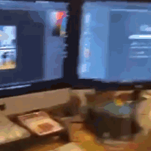 a blurred image of two computer monitors on a desk with one showing a picture