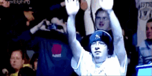 a man wearing a new york yankees hat is raising his hands in the air