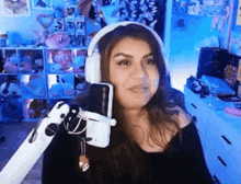 a woman wearing headphones is sitting in front of a microphone in a room .