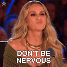 a woman sitting in front of a microphone with the words " do n't be nervous " written on her face