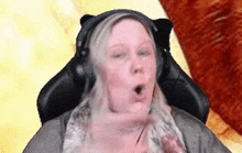 a woman is wearing headphones and making a funny face .
