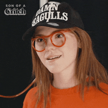 a woman wearing a hat that says damn seagulls on it