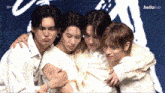 a group of young men and women are hugging each other and making funny faces .