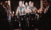 a group of men are holding barbells in a dark room