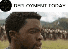 a man is standing in a field with the words " deployment today " above him