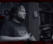a man in a black shirt is making a hand gesture with the words " tadaaaaa " written on it