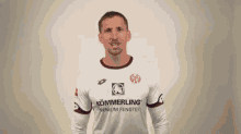 a man wearing a white shirt that says konmerling