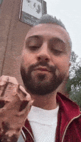 a man with a beard is eating an ice cream cone .