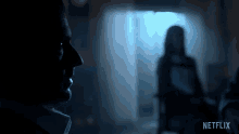 a man in a dark room with a netflix logo behind him