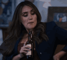 a woman is holding a bottle of beer and a bowl of food