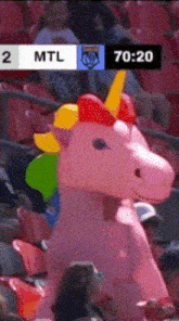 a pink inflatable unicorn stands in the stands during a game between the mtl and the toronto raptors
