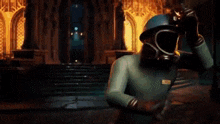 a man in a gas mask is standing in front of a building with a light coming out of his eyes .