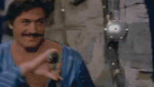 a man with a mustache wearing a blue shirt