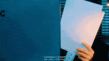 a person is holding a piece of paper in front of a sign that says c.