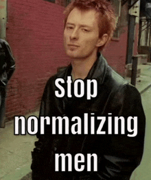 a man in a leather jacket is standing on a sidewalk with the words stop normalizing men written below him .