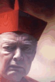 a close up of a man 's face with a red hat on his head