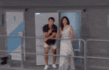 a man and a woman are standing in front of a door and making funny faces