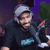 a man wearing headphones is sitting in front of a microphone and making a face .