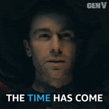 a man in a dark room with the words the time has come