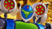 a robot with a green face and a red arrow pointing down has a sticker that says okoo on it