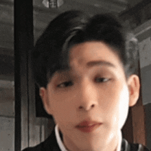 a close up of a young man 's face with his eyes closed and his mouth open .