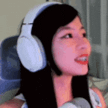 a woman wearing headphones is smiling and looking to the side .