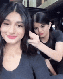 two women are sitting next to each other in a car
