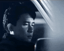 a black and white photo of a man in a car