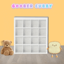 a teddy bear sits next to an empty shelf with the words goober cubby above it