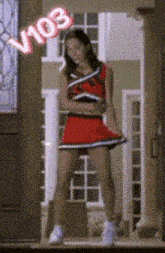 a cheerleader is standing in front of a door with v103 written on it