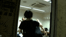 a man in a black shirt is standing in front of a door that says ' ahaha shisha ' on it