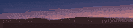 a sunset with mountains in the foreground and a purple sky