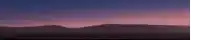 a sunset with mountains in the foreground and a purple sky