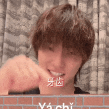 a man is brushing his teeth in front of a brick wall that says ya chi