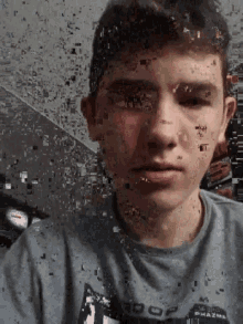 a young man wearing a gray shirt that says ' pharma ' on it