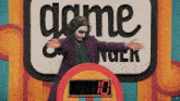 a man in a joker costume stands in front of a sign that says game nuck