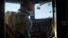 a man is sitting in the cockpit of a plane with a clock on the dashboard that says ' a '