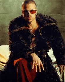 a man is wearing a fur coat and sunglasses while sitting on a bed .