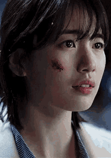 a close up of a woman 's face with a wound on it .