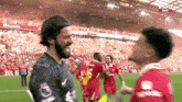 two soccer players are shaking hands on a field with espn live in the background