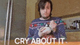 a man in an ugly sweater is eating a bowl of cereal with the words cry about it above him