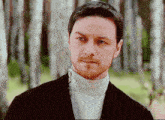 a man with a beard wearing a turtleneck and a black jacket