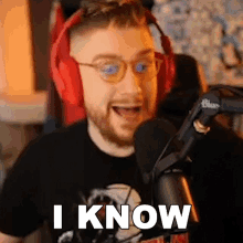 a man wearing headphones and glasses is talking into a microphone and says i know .