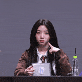 a girl is sitting at a table with a bottle of kangaroo water in front of her