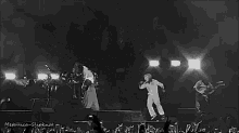 a black and white photo of metallica playing a concert .