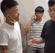 a man wearing a face mask is talking on a cell phone