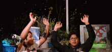 two men are raising their arms in the air and one of them has a shirt that says ' world of warcraft ' on the front