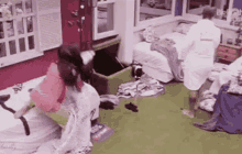 a man and a woman are fighting in a messy room .