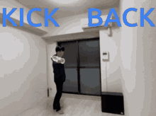 a person standing in a room with the words kick back written in blue
