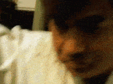 a blurry picture of a person 's face with a white shirt on .